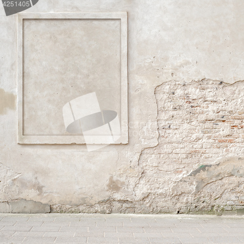 Image of abandoned cracked brick wall with a stucco frame