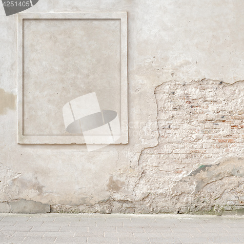 Image of abandoned cracked brick wall with a stucco frame