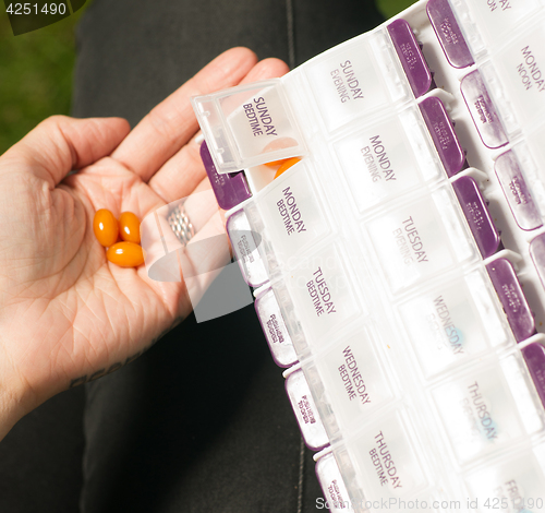 Image of Woman Takes Last Day Sunday Medication Vitamins