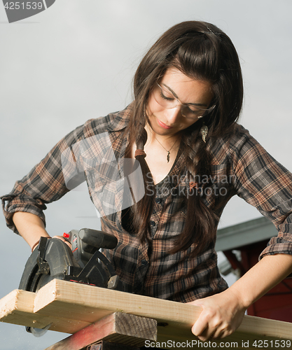 Image of Craftsperson Woman Uses Circular Saw Cutting Wood