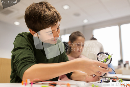 Image of happy children building robot at robotics school