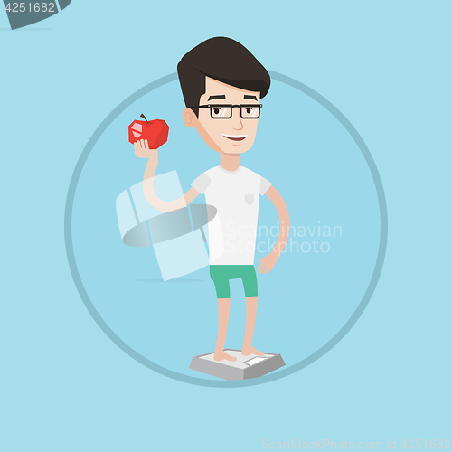 Image of Man standing on scale and holding apple in hand.