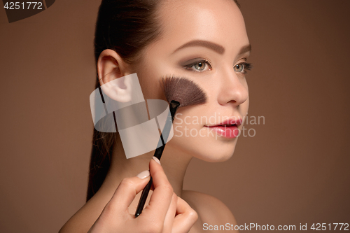 Image of Beauty Girl with Makeup Brush. Perfect Skin. Applying Makeup