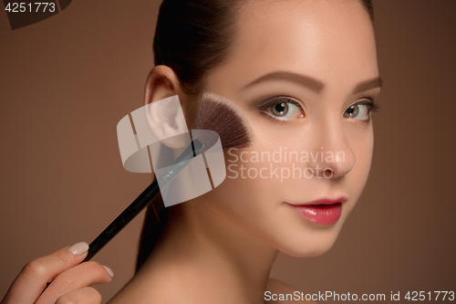 Image of Beauty Girl with Makeup Brush. Perfect Skin. Applying Makeup