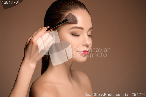 Image of Beauty Girl with Makeup Brush. Perfect Skin. Applying Makeup