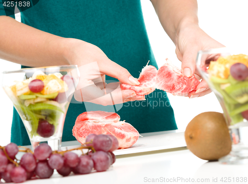 Image of Cook is peeling grapefruit for fruit dessert