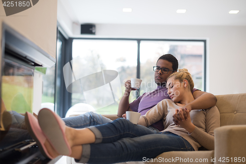 Image of Young multiethnic couple  in front of fireplace