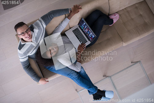 Image of happy multiethnic couple relaxes in the living room