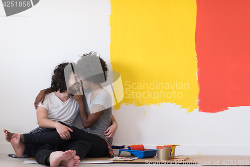 Image of young multiethnic couple relaxing after painting