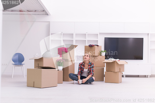 Image of woman with many cardboard boxes sitting on floor