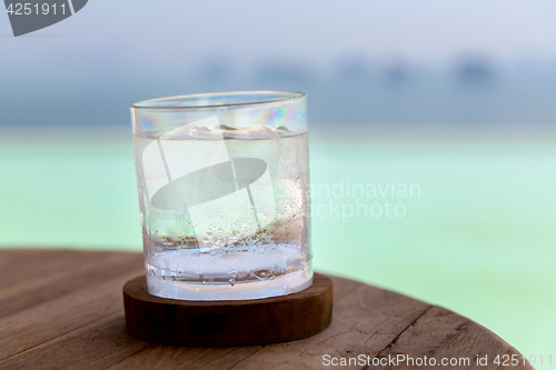 Image of glass with cold water or cocktail on bar table