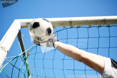 Image of goalkeeper with ball at football goal over sky