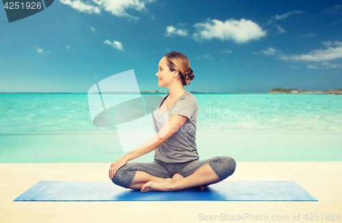 Image of woman making yoga in twist pose on mat