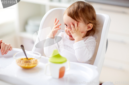 Image of baby sitting in highchair and eating at home