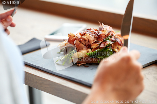 Image of woman eating prosciutto ham salad at restaurant