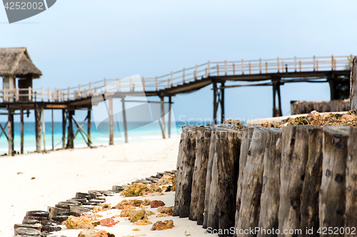 Image of stilt bridge to bungalow hut on tropical beach