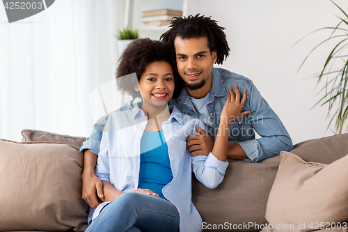 Image of happy couple sitting on sofa at home