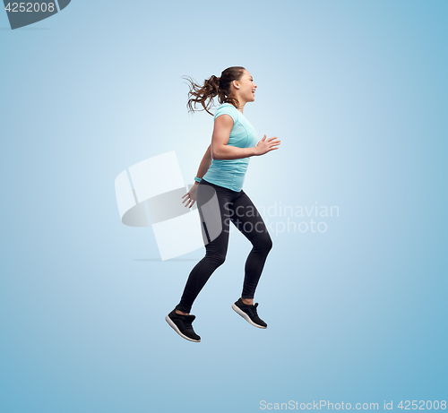 Image of happy smiling sporty young woman jumping in air