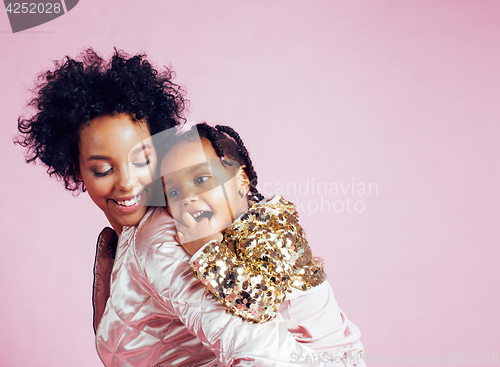 Image of young pretty african-american mother with little cute daughter hugging, happy smiling on pink background, lifestyle modern people concept