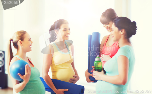 Image of group of happy pregnant women talking in gym