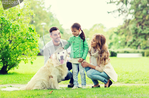 Image of happy family with labrador retriever dog in park