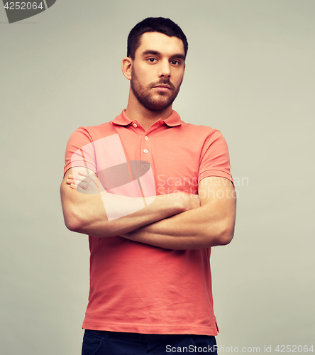 Image of young man with crossed arms over gray background