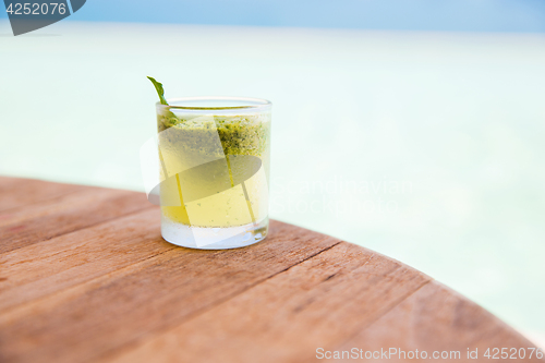 Image of glass with drink or cocktail on bar table