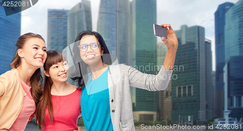 Image of international happy women taking selfie in city