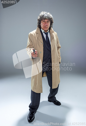 Image of Senior police agent with a gun on dark smoke background