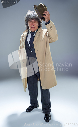 Image of The senior man as detective or boss of mafia on gray studio background