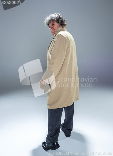 Image of The senior man as detective or boss of mafia on gray studio background