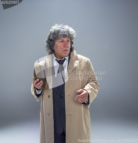 Image of The senior man as detective or boss of mafia on gray studio background