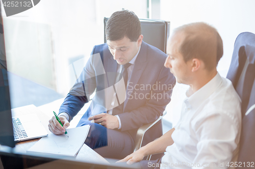 Image of Two businessmen discussing a bisiness problem at meeting in trading office.