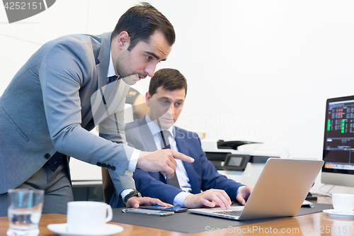 Image of Business team remotely solving a problem at business meeting using laptop computer and touchpad.