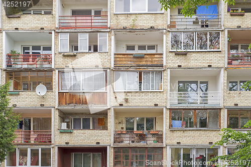 Image of Old building with balconies full of flowers, tables, chairs