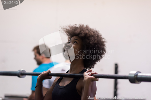 Image of black woman lifting empty bar