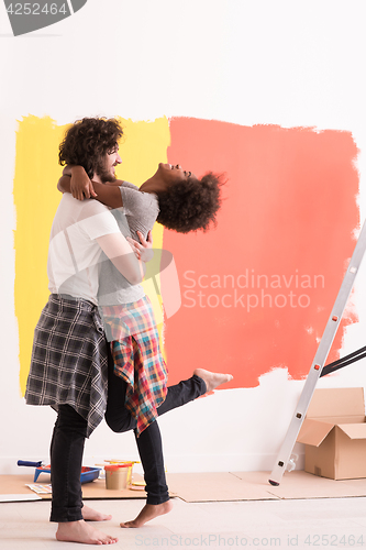 Image of Young happy multiethnic couple hugging