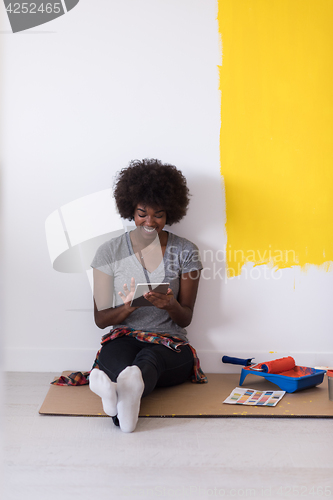 Image of back female painter sitting on floor