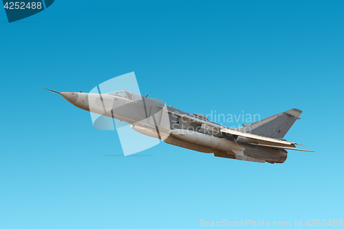 Image of Military jet bomber Su-24 Fencer flying a blue background