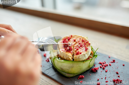 Image of woman eating goat cheese salad at restaurant