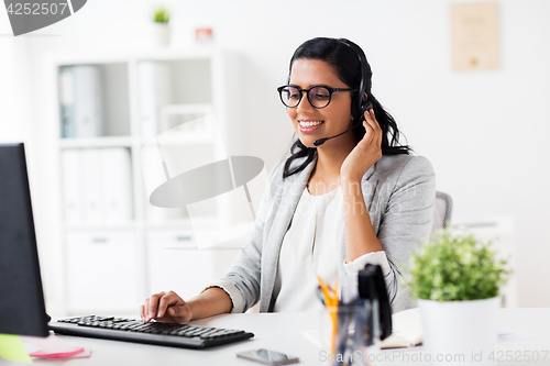 Image of businesswoman with headset and computer at office