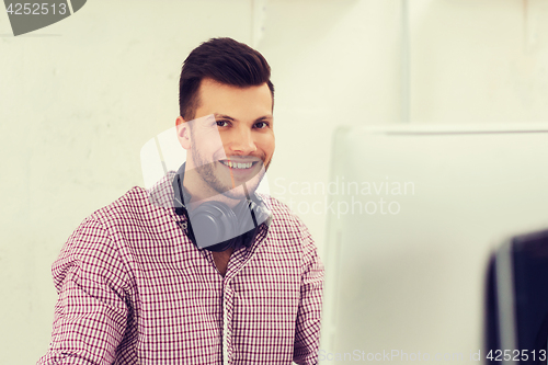 Image of creative man with headphones and computer