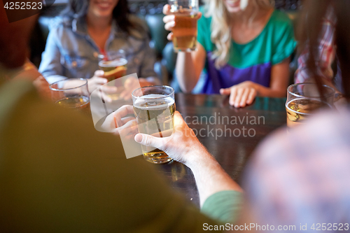 Image of friends drinking beer at bar or pub