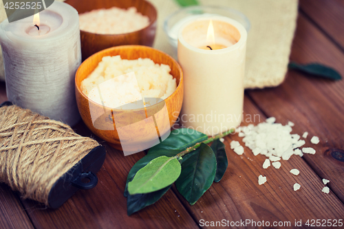 Image of close up of natural body scrub and candles on wood