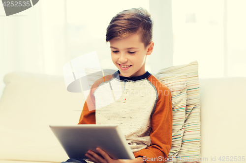 Image of smiling boy with tablet computer at home