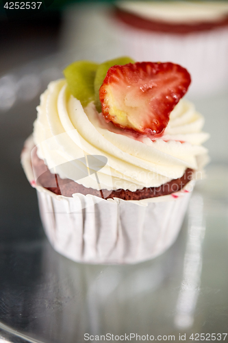 Image of close up of cupcake with cream and strawberry