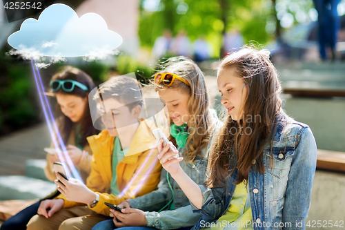 Image of happy teenage friends with smartphones outdoors