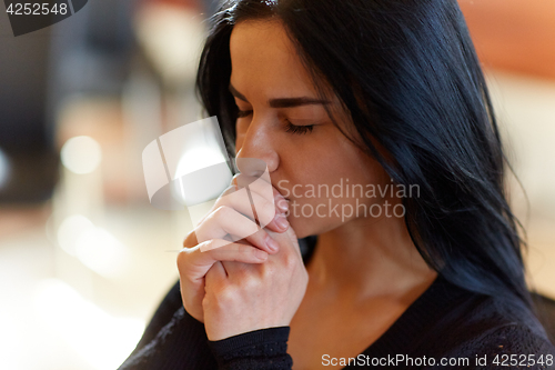 Image of close up of unhappy woman praying god at funeral