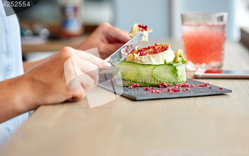 Image of woman eating goat cheese salad at restaurant