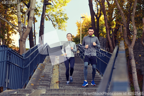 Image of happy couple running downstairs in city